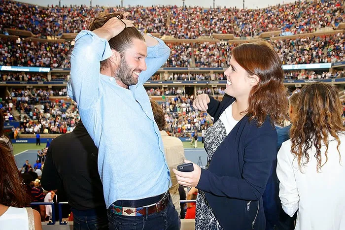 Tennis fan Princess Eugenie giggles as she watches the men's final with friend Phil Winser