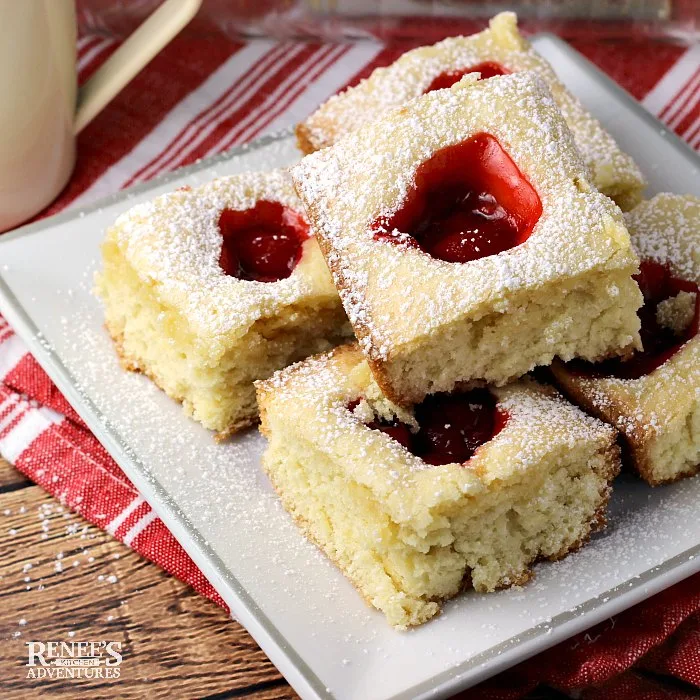 Shelly's Cherry Squares by Renee's Kitchen Adventures stacked on a white plate with a red and white napkin in the background