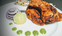 Restaurant style Tandoori chicken recipe served with green chutney, lemon wedges and onion slices