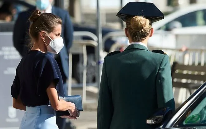 Queen Letizia wore a v-neck pure silk flared sleeves navy blue top and a sky-blue high waisted pencil skirt from Hugo Boss