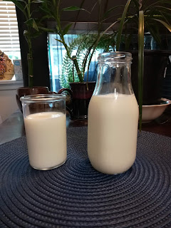 Tube shaped glass of milk on left, standard wide bottle on right, also holding milk