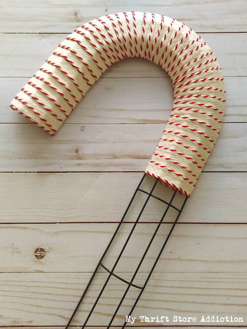 Run to the dollar store to grab a candy cane wire form so you can create one of these farmhouse style wreaths! DIY dollar store candy cane wreath