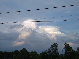 Clouds in the sky with tress in the back