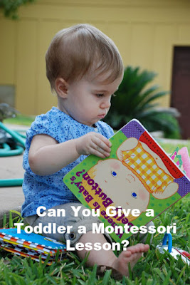 Toddler sitting on grass looking at board books
