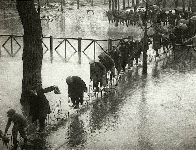 24 Rare Historical Photos That Will Leave You Speechless - People in Paris avoid getting wet in the flood by stepping on a series of chairs in 1924.