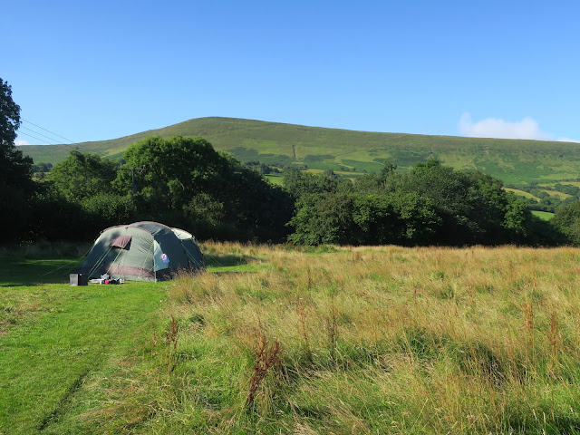 Tent in field with Black Mountains in the background.