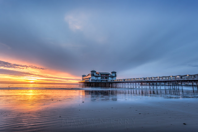 Evening sunshine below storm clouds over Weston-Super-Mare and the Grand Pier