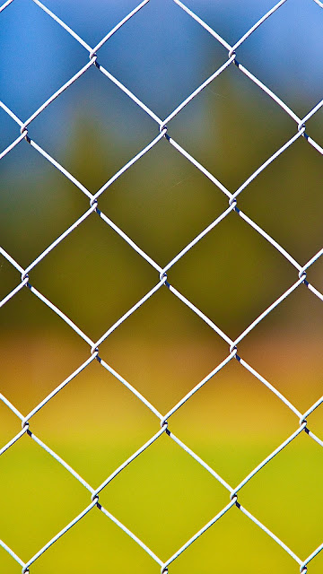 Desktop wallpaper with metal fence and iPhone