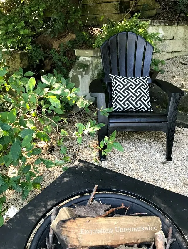 Black Adirondack chair on patio with fire pit
