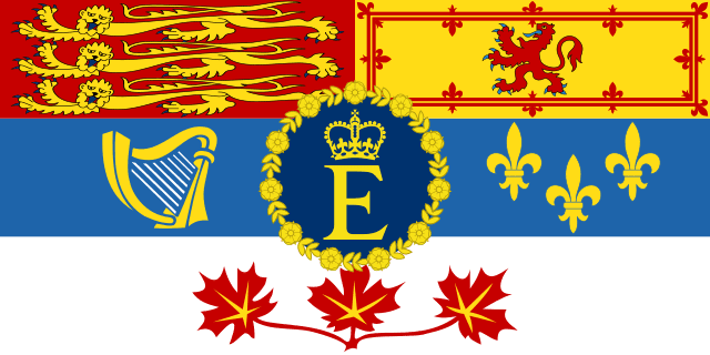 Flag of Elizabeth II, Queen of Canada. The queen's gold and blue personal symbol is featured at center, with the top two-thirds of the background divided into four boxes each with a different heraldic symbol, and the bottom third white with three red maple leaves connected at the stems.