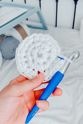 A crocheted circle with a crochet needle