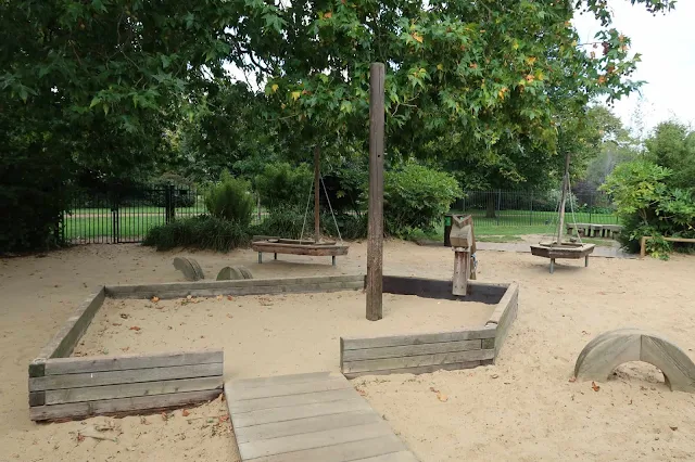 Some wooden boat structures in a sand pit a Diana Memorial Park in London