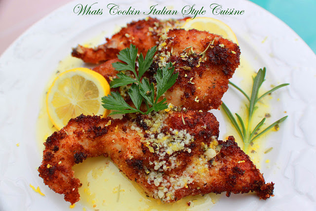 Italian fried chicken cutlets on a plate with lemon and rosemary sprigs