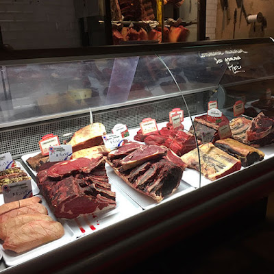 The meat counter at Bar de Boucher, Bordeaux, with five dark, well-aged pieces of beef on the front row.