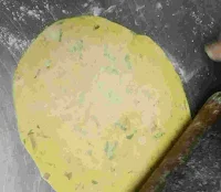 Rolling Missi roti with a roller pin