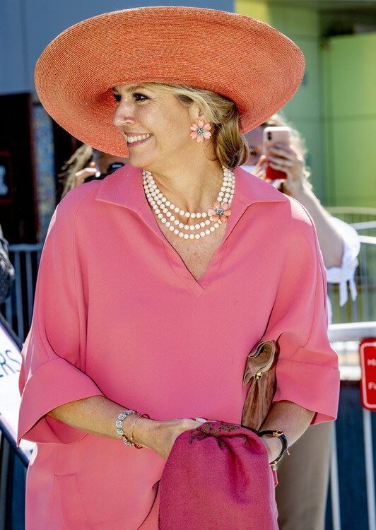 Queen Maxima wore pink silk shirt and wide-leg silk pants from Natan, and flower coral earrings from Van Cleef and Arpels