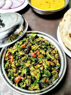 Serving bhindi ki sabji bhindi fry in a bowl with dal and roti