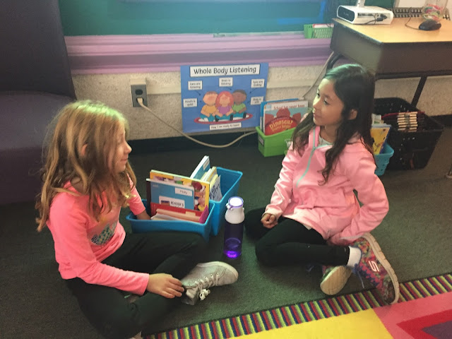 two kids talking on carpet during readers workshop
