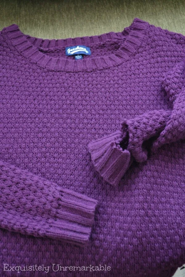 Purple sweater with a hole in the sleeve