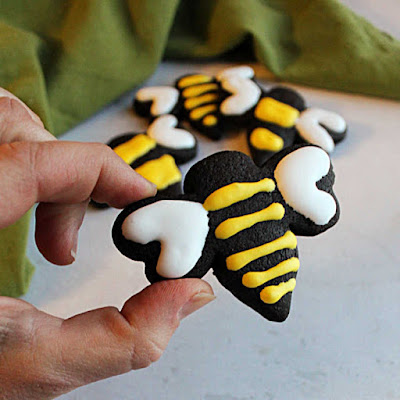 These chocolate cookies have a deep dark color, perfect chocolate flavor and are perfect for rolling out and cutting into shapes. Your decorated cookie game just went to the next level! black chocolate bee cookie with yellow icing stripes and white icing wings
