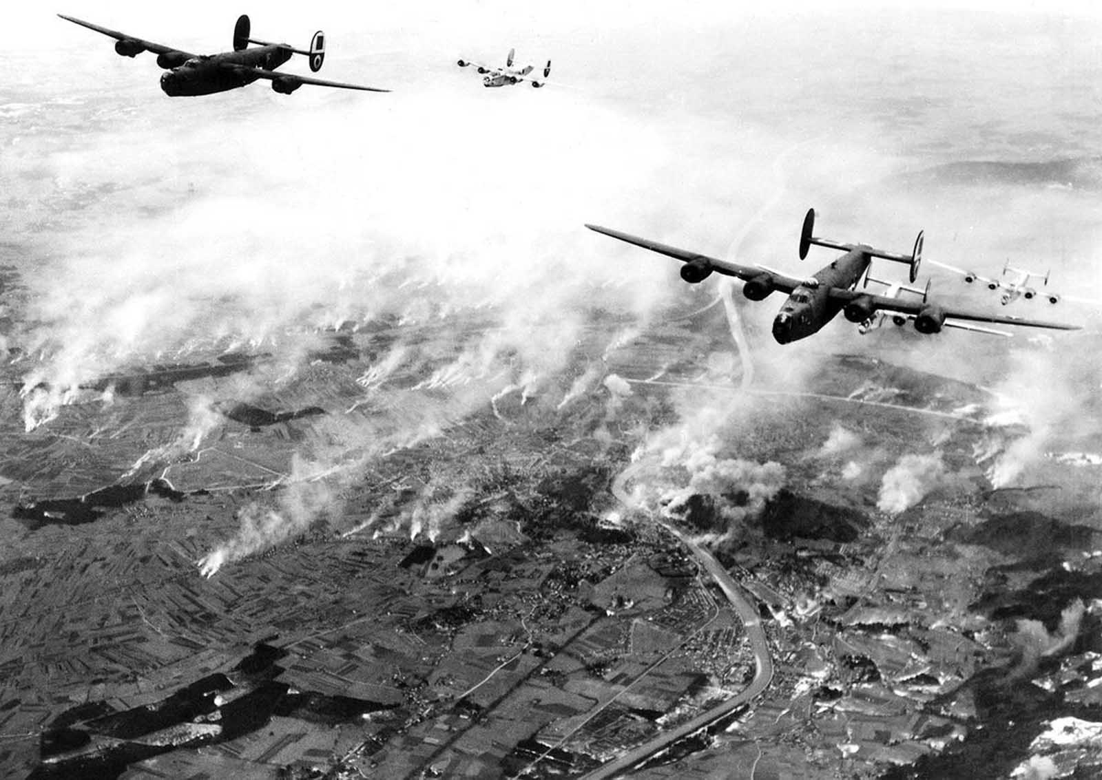 A formation of B-24s of Maj. General Nathan F. Twining's U.S. Army 15th Air Force thunders over the railway yards of Salzburg, Austria, on December 27, 1944. The smoke created by their bombs mingles with that from the enemy's many smudge pots.