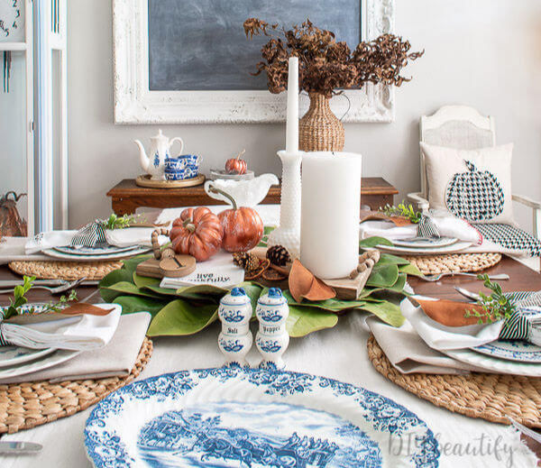 Thanksgiving table decor with blue vintage dishes, copper pumpkins, magnolia leaves