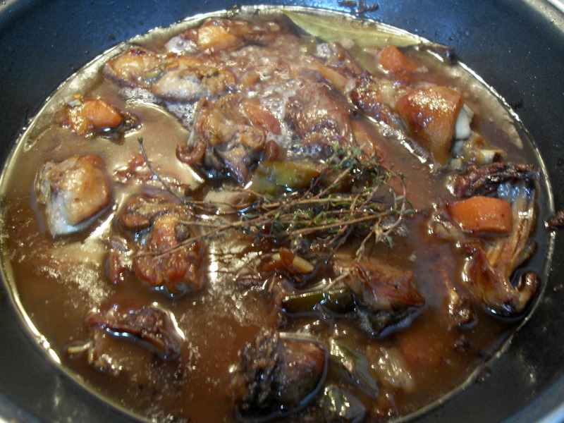 Cociendo el conejo con el vino y las verduras.