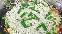 Ading boiled noodles with chopped spring onion with vegetables for chicken hakka noodles recipe