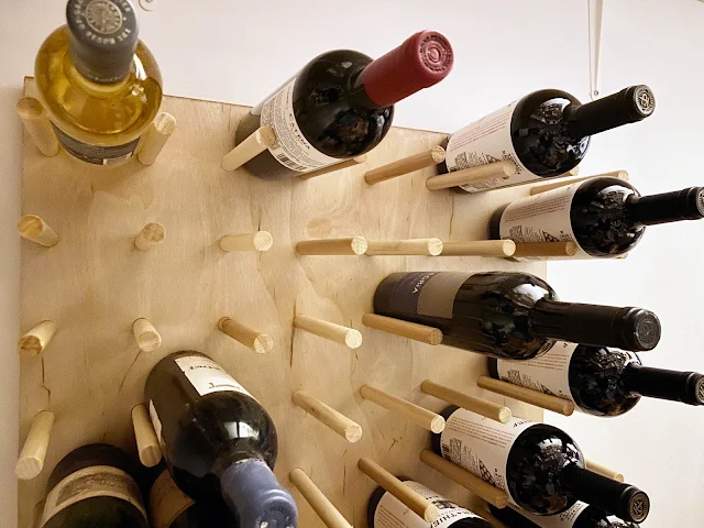 organized wine bottles on pegboard rack