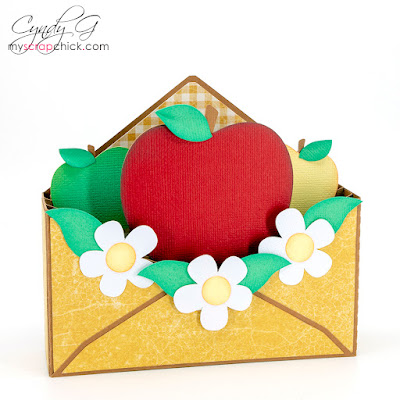 Apples in an envelope with white flowers.