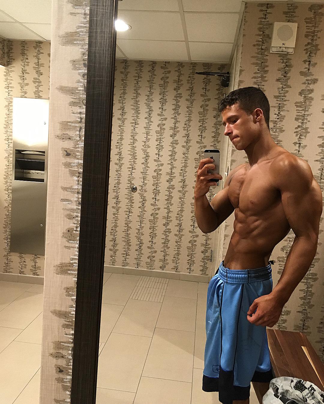 young-hunky-teen-bodybuilder-shirtless-fit-muscular-body-selfie-blue-shorts-big-biceps-sexy-tanned-bro