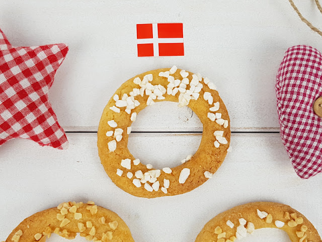 Rezept für Kaerlighedskranse: Das dänische Weihnachtsgebäck mit Herz. Die runden Kränze bzw. Kringel werden mit Mandeln oder Hagelzucker bestreut und sind ein köstliches Gebäck zu Weihnachten.
