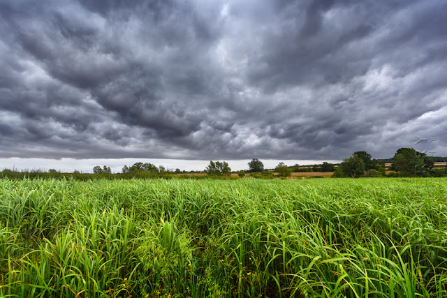 Rural Oxfordshire field with dark stormy clouds above by Martyn Ferry Photography