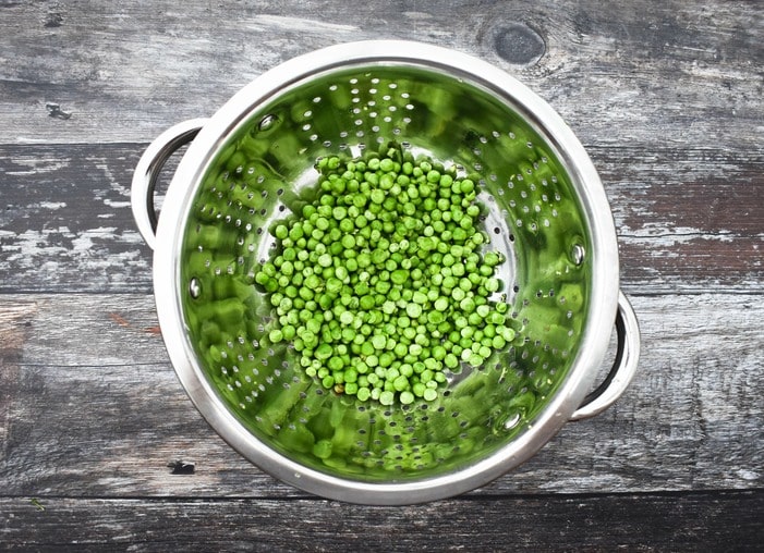 frozen peas frozen peas in a colander