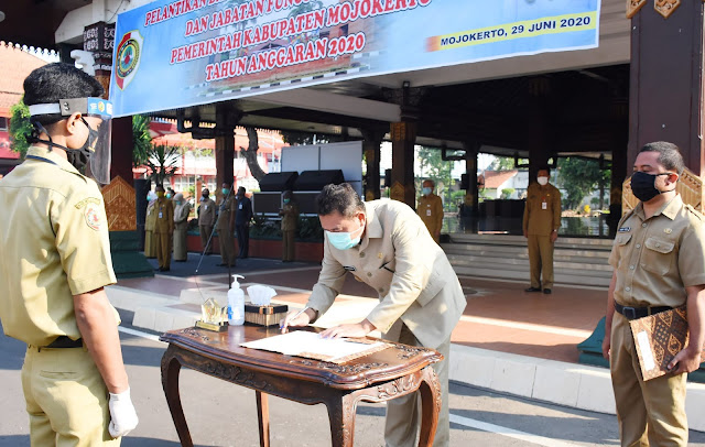 Mojokerto - Bupati Mojokerto Pungkasiadi, melantik sekaligus mengambil sumpah jabatan atau mutasi 216 orang yang terbagi atas 205 Pegawai Negeri Sipil (PNS) dan 11 Jabatan Fungsional Guru, Senin (29/6) pagi di halaman Kantor Pemerintah Kabupaten Mojokerto. Pelantikan digelar dengan tetap menerapkan protokol kesehatan pencegahan Covid-19 secara ketat.  Bupati Pungkasiadi, pada sambutan arahan menitipkan harapan agar para ASN yang dilantik, mampu melaksanakan tugas sebaik-baiknya sesuai ketetapan tugas dan fungsi.  “ASN harus berkompeten dan mencapai kinerja terbaik, punya integritas nasionalisme, mendukung birokrasi yang bersih, berwawasan global, menguasai teknologi informasi dan bahasa asing, punya jaringan dan jiwa kewirausahaan dengan mengoptimalkan ilmu pengetahuan berikut keahlian,” pesan bupati yang hadir didampingi Sekdakab Hery Suwito, Asisten dan Staf Ahli  Susantoso Kepala Badan Kepegawaian, Pendidikan dan Pelatihan (BKPP) Kabupaten Mojokerto, dalam laporan sambutan menerangkan jika pelantikan dimaksudkan untuk menyelenggarakan manajemen ASM berbasis sistem merit.  “Pelantikan ini kita harap dapat menghasilkan PNS profesional, memiliki nilai dasar, etika, bebas dari intervensi politik, bersih dari KKN dalam pelayanan tugas publik, tugas pemerintahan dan tugas pembangunan tertentu,” terang Susantoso. (Jayak)