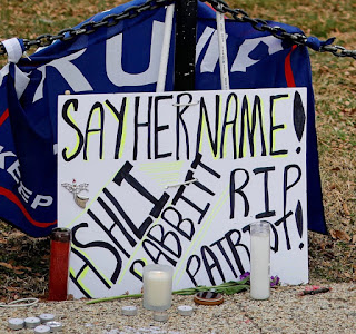 Sign: "Say her name! Ashli Babbitt, RIP Patriot?" with memorial candles in front