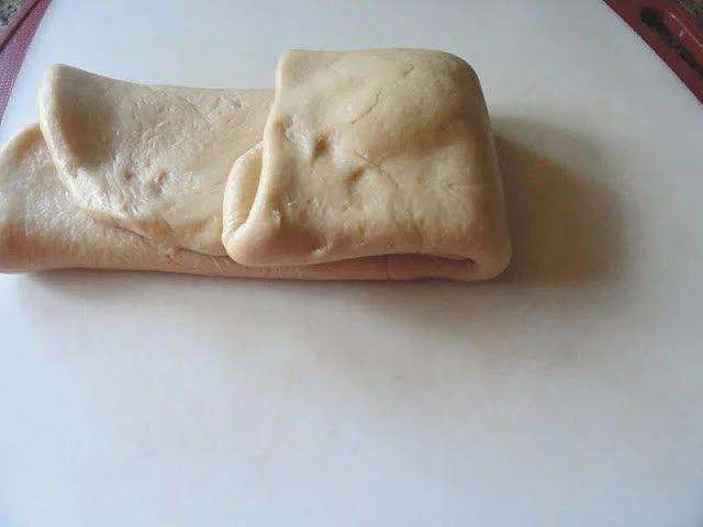Cinnamon Roll dough being folded in thirds.