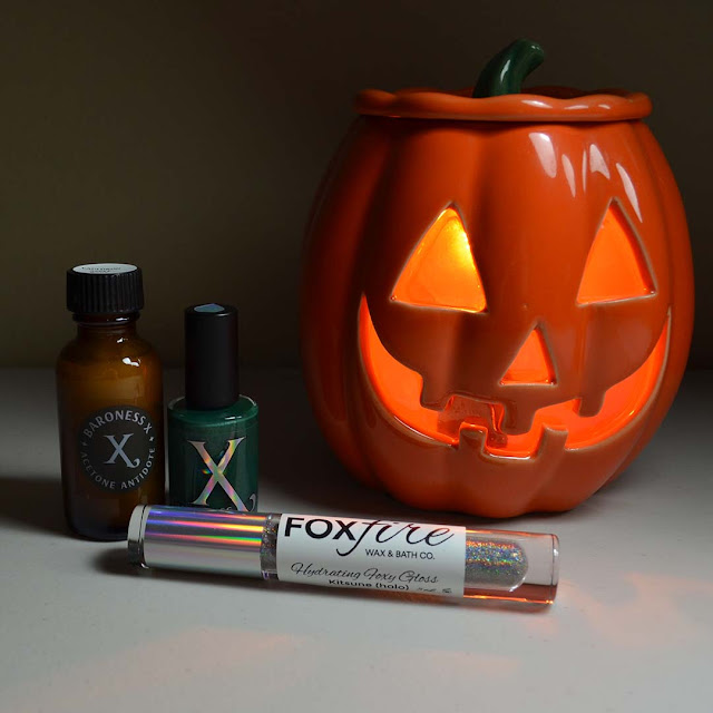 nail polish, acetone additive, lip balm staged next to light up pumpkin