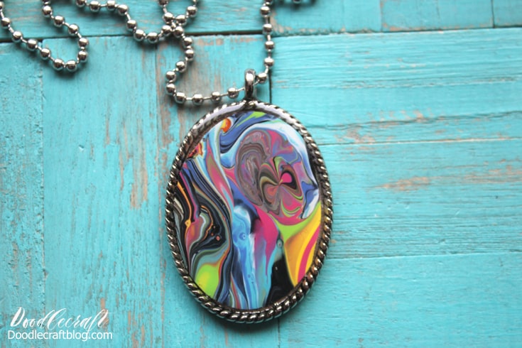 Dirty pour acrylic flo painting art canvas over spill skins turned into stunning pendant bezel jewelry topped with glossy resin.