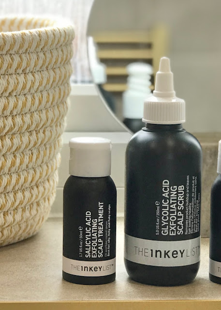 Two black bottles standing on a window sill