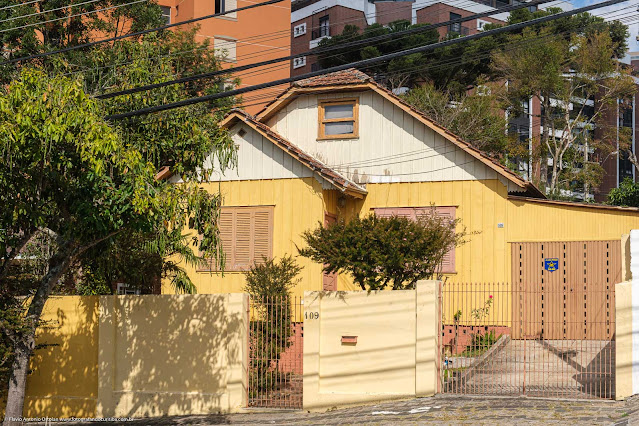 Casa de madeira pintada de amarelo e branco