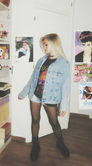 Estilo grunge con camiseta negra ancha con imagen del grupo The Doors, pantalón corto, medias de red pequeña, botas estilo militar y cazadora vaquera