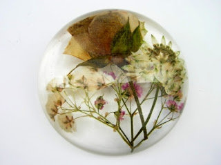 Special occasion flowers preserved within a paperweight
