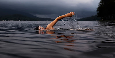 Activities Entrepreneurs Should Do on the Weekend -By David Milberg Guy with cap swimming in a lake