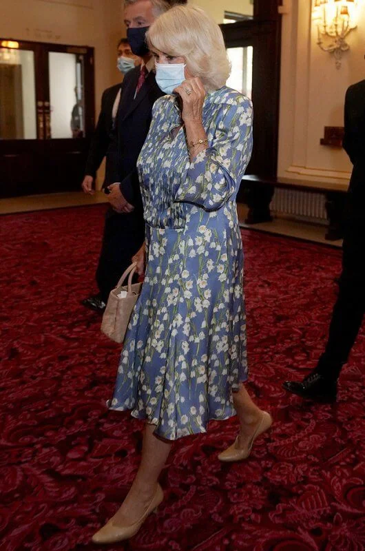 Camilla wore a floral silk blue dress from Fiona Clare, and she carried beige leather bag from Bottega Veneta