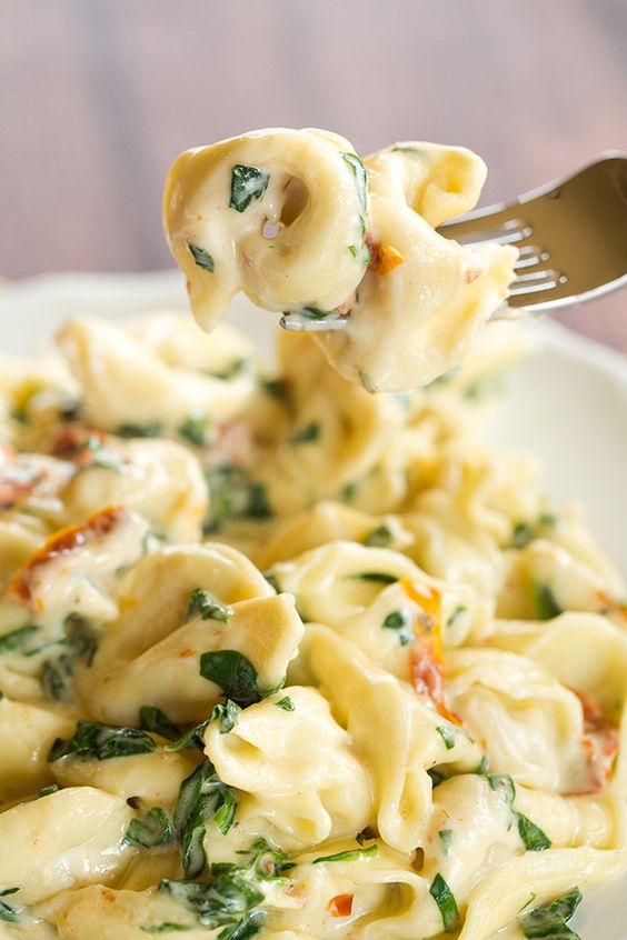Cheese tortellini are tossed in an easy Parmesan cream sauce with spinach and sun-dried tomatoes.
