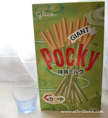 Giant Pocky green tea next to drinking glass