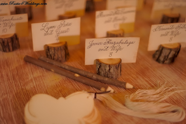 Rustic Tree Branch Place Card Holders Alongside Some Tree Branch Pens
