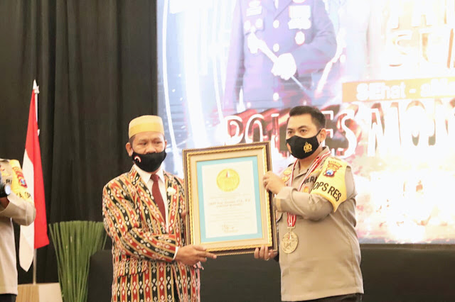 Mojokerto - Lembaga Prestasi Indonesia Dunia memberikan rekor penghargaan ke 614 pada Polres Mojokerto atas Program inovatif peningkatan disiplin penerapan protokol covid-19 melalui Hypnotherapy Tangguh Semeru massal dan serentak di 236 desa Se-Kabupaten Mojokerto yang pertama kali di Indonesia bahkan di Dunia, Sabtu (24/10/2020) di Hotel Aula Ayola Sunrise Mall Lantai 3, Jalan Benteng Pancasila, Kota Mojokerto.  Ketua Lembaga Prestasi Indonesia Dunia (LEPRID), Paulus Pangka mengucapkan selamat atas terciptanya rekor Program inovatif peningkatan disiplin penerapan protokol covid-19 melalui Hypnotherapy tangguh semeru massal dan serentak di 236 desa Se-Kabupaten Mojokerto yang diikuti oleh kurang lebih 10000 peserta.  "Program ini Pemrakarsanya adalah Kapolda Jatim dan Kapolres Mojokerto. Untuk pematerinya adalah Wakapolres Mojokerto dan Kanit Dikyasa Polres Mojokerto. Kemudian untuk penyelenggaranya adalah Kasat Lantas Polres Mojokerto dan Kasat Reskrim Polres Mojokerto," ujar Paulus.  Menanggapi hal tersebut, Kapolres Mojokerto AKBP Dony Alexander mengucapkan terima kasih banyak atas penghargaan yang telah diberikan Lembaga Prestasi Indonesia Dunia.  "Semoga dengan program ini kita bisa lebih mematuhi protokol kesehatan. Jadi, kegiatan ini bisa dilakukan untuk masuk ke alam bawah sadar yang pada hari ini diikuti oleh 10000 peserta dari 236 desa Se-Kabupaten Mojokerto secara Webinar. Semoga hal seperti ini bisa menjadi agenda untuk bertindak disiplin dalam mencegah covid-19 meskipun tanpa diawasi aparat. Semoga dari zona orange ini, dengan program Hypnotherapy Tangguh Semeru ini bisa berubah jadi kuning lalu jadi zona hijau," ungkap AKBP Dony Alexander.  Sementara itu, Pjs Bupati Mojokerto Himawan Estu Bagijo mengatakan semoga 10000 peserta yang tadi mengikuti program ini bisa menjadi pahalawan kesehatan untuk tetap melaksanakan protokol kesehatan.  "Saya sangat mengapresiasi program ini. Karena hal ini adalah upaya yang lain daripada yang lain yaitu dengan Hypnotherapy. Saya tadi ikut, melihat dan merasakan. Saya bisa merasakan, saya tadi bisa berada di ruang kesadaran kita yang paling dalam. Hal itu nantinya bisa dipanggil lagi untuk patuh terhadap protokol kesehatan. Program ini nantinya akan kita adopsi juga di wilayah Pemkab Mojokerto," kata Himawan. (Jayak)