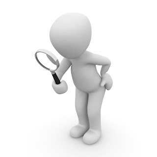 Figure holding magnifying glass